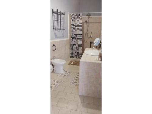 La salle de bains est pourvue d'une baignoire, de toilettes et d'un lavabo. dans l'établissement Borgo Santo Stefano, à Oschiri