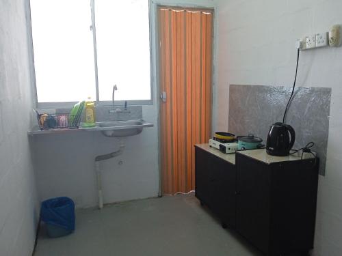 een badkamer met een oranje douchegordijn en een wastafel bij Homestay Indrawasih with 2 Bedroom in Perai
