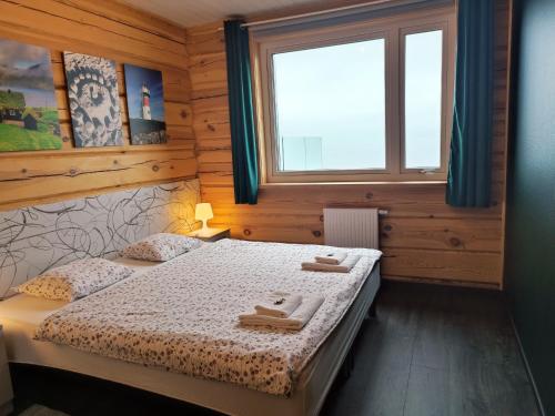 a bedroom with a bed with towels on it at Gøtugjógv Log House in Gøtugjógv