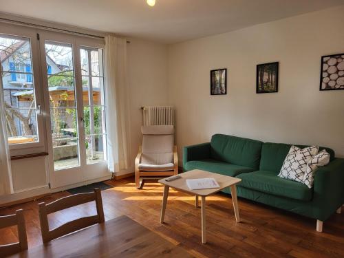 a living room with a green couch and a table at Interlaken Apartments in Interlaken