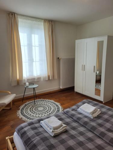 a bedroom with a bed and a table and a window at Interlaken Apartments in Interlaken