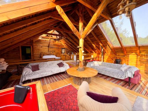 Cette grande chambre en bois comprend 2 lits et une table. dans l'établissement Aynştayn Chalet, à İznik