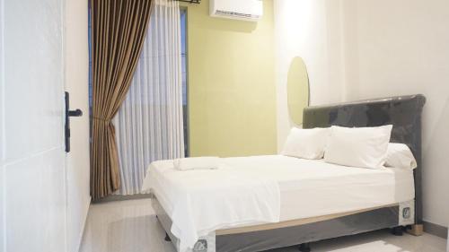 a bed with white sheets and pillows in a room at Safar Homestay Dekat JEC in Demangan