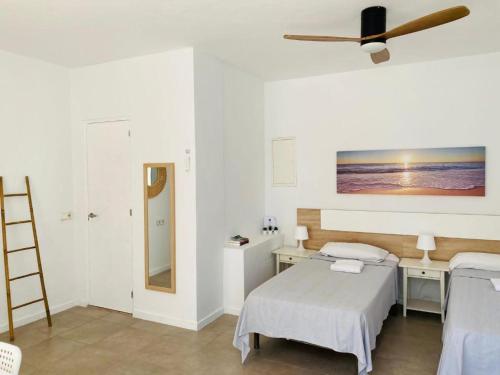 1 dormitorio con 1 cama y ventilador de techo en Apartamentos Cana Sofía, en Cala Llonga