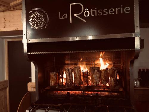 a fireplace with a bunch of food cooking in it at Terra-Beka Lodge in La Chapelle-dʼAbondance