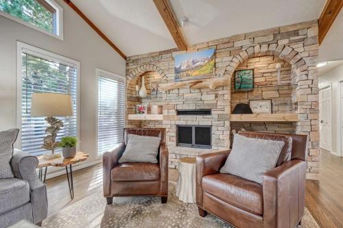 a living room with two chairs and a stone fireplace at Briarhaven Forest BBQ & Patio & Fast WiFi in Monument