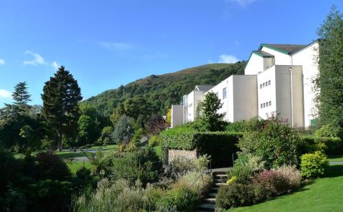 a building with a garden in front of a mountain at Cosy Double Room in Quiet Cul-de-sac. in Malvern Link