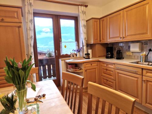 cocina con armarios de madera, mesa y ventana en Appartement am Hauser Kaibling, en Haus im Ennstal