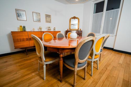 mesa de comedor con sillas y espejo en La maison Janisse, en Limoges