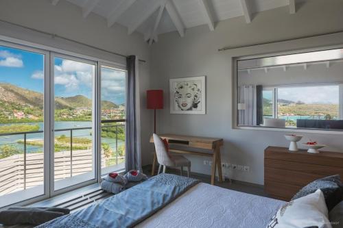 Schlafzimmer mit einem Bett, einem Schreibtisch und einem Fenster in der Unterkunft Luxury Vacation Villa 15 in Saint Barthelemy