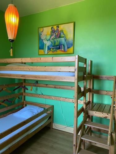 - une chambre avec 2 lits superposés et un mur vert dans l'établissement Domaine de Linars ☆ L'Étage du Château ☆, à Le Truel