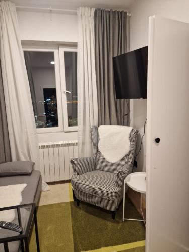 uma sala de estar com uma cadeira e uma janela em Nest em Sajmište