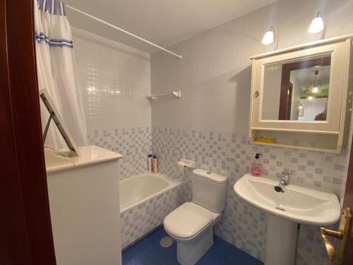 Un baño con inodoro, lavabo y bañera. en Los caballos beach apartment, en Cuchía
