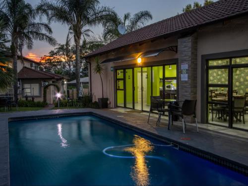 a swimming pool in front of a house at Sleep in Beauty Guesthouse in Newcastle