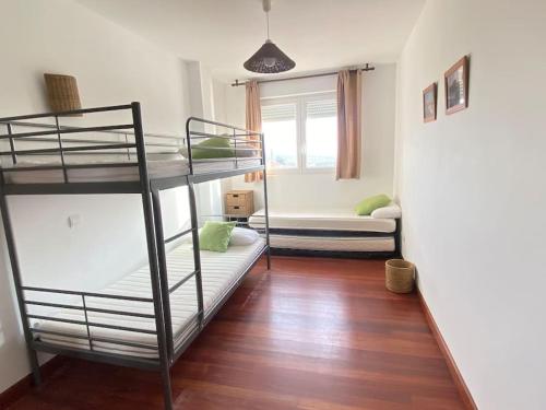 una habitación con dos literas y una ventana en Los caballos beach apartment, en Cuchía
