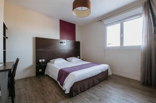 Un dormitorio con una cama grande y una ventana en Hotel-Restaurant La Caborne, en Limonest