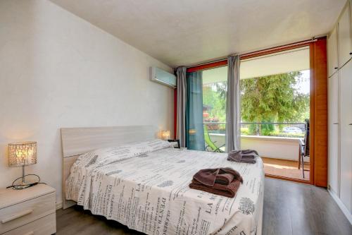 Un dormitorio con una cama y una ventana grande en Il Sogno del Lago by Garda FeWo, en Manerba del Garda