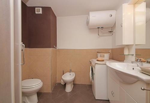 Un baño pequeño con inodoro y lavabo. en Il Sogno del Lago by Garda FeWo, en Manerba del Garda