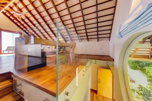 an internal view of a house with a wooden ceiling at Cinnamon Velifushi Maldives in Keyodhoo