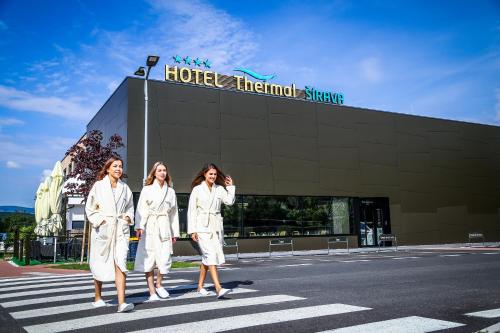 卡魯札的住宿－Hotel Thermal ŠÍRAVA，站在一幢楼前身的三名身着白色长袍的女性