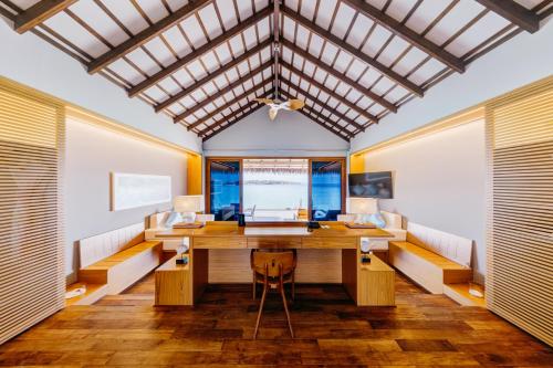 an office with a wooden desk in a room with windows at Cinnamon Velifushi Maldives in Keyodhoo