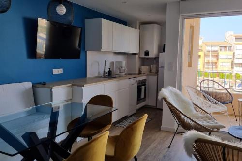 une cuisine avec une table en verre et des chaises dans une pièce dans l'établissement Appartement calme avec vue sur les bateaux, au Cap d'Agde