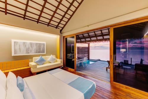 a bedroom with a bed and a view of the ocean at Cinnamon Velifushi Maldives in Felidhoo 
