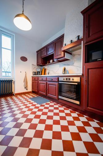 une cuisine avec un sol en damier et des armoires dans l'établissement La maison Janisse - gîte en centre-ville avec jardin, à Limoges