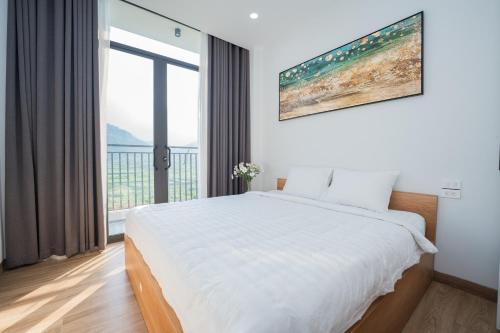 1 dormitorio con cama blanca y ventana grande en Ami Villa Ba Vì, en Ba Vì