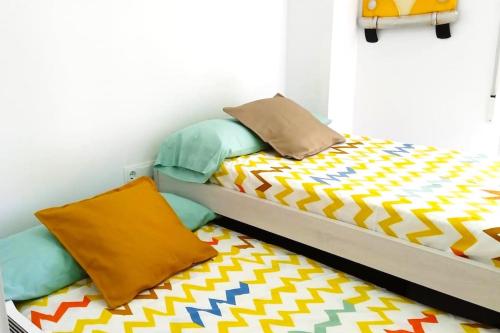 a bedroom with a bed with a colorful comforter at Apartamento frente al mar in Cullera