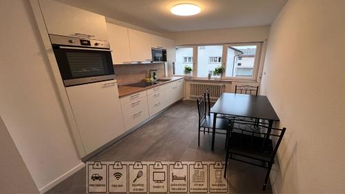 - une cuisine et une salle à manger avec une table et des chaises dans l'établissement Business Apartment Bühl, à Buhl
