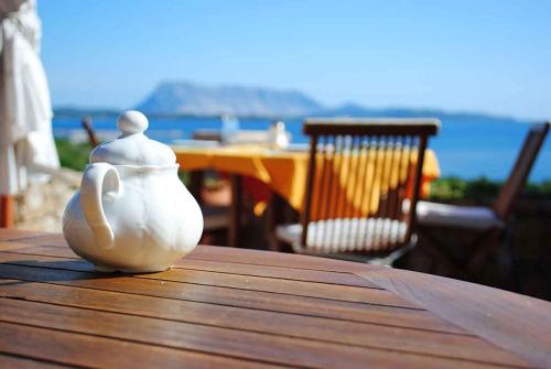 eine weiße Vase auf einem Holztisch in der Unterkunft Villa Minda Lodge & View in San Teodoro