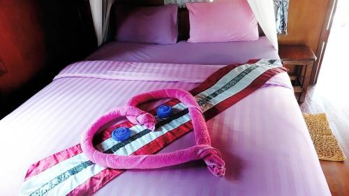 un asciugamano rosa su un letto con pillole blu di Nadia Resort Kohjum a Koh Jum