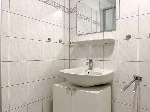 a white bathroom with a sink and a mirror at Sünnslag Wohnung 057 in Boltenhagen