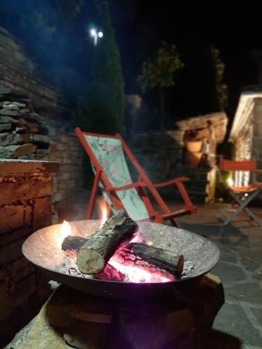 a fire pit with a piece of wood and a chair at Lila Traditional House in Kipoi