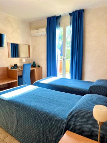 a hotel room with two beds and a window at Acqua di Mare in Bordighera