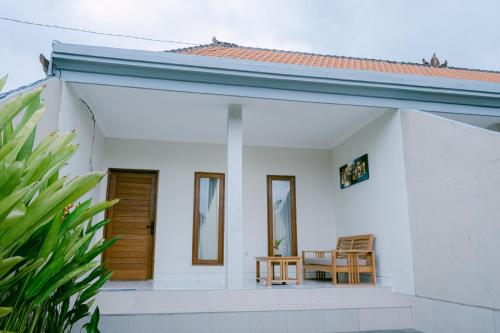 a white house with two chairs and a table at Sriwedari House Keramas in Gianyar