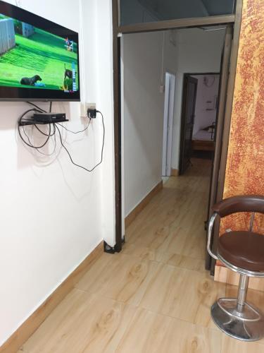 Suryalaxmi guest house في غاواهاتي: تلفزيون معلق على جدار في غرفة
