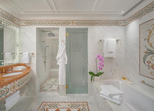 a bathroom with a tub and a shower and a sink at Palazzo Versace Macau in Macau