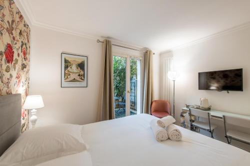 Schlafzimmer mit einem Bett, einem Schreibtisch und einem Fenster in der Unterkunft Geranimus Versailles Charost in Versailles