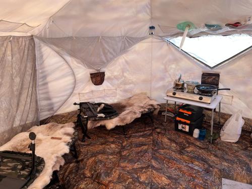 uma tenda com uma mesa e um fogão em Aurora Tent Camp em Karasjok