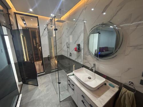 a bathroom with a sink and a shower and a mirror at شقة 200 متر جديدة بالكامل للايجار في الحى التاسع مدينة العبور القاهرة in Obour