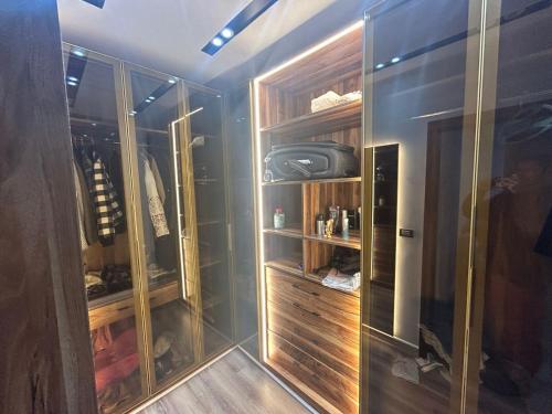 un vestidor con puertas de cristal y estanterías de madera en شقة 200 متر جديدة بالكامل للايجار في الحى التاسع مدينة العبور القاهرة, en Obour