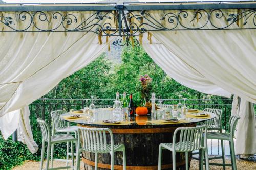 a table and chairs under a canopy with a table and chairs at AGRITURISMO CA' FENILE in Alzano Lombardo