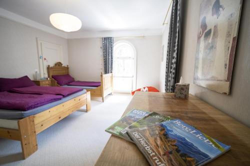 um quarto com uma cama e uma mesa com um livro em Villa Victoria - Nairs, Scuol em Scuol