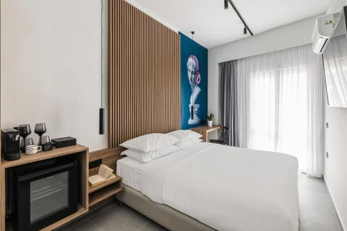 a bedroom with a white bed and a television at The Q Hotel in Athens