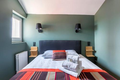 a bedroom with a large bed with green walls at Hamac Suites - Le Franklin - 4 people in Lyon