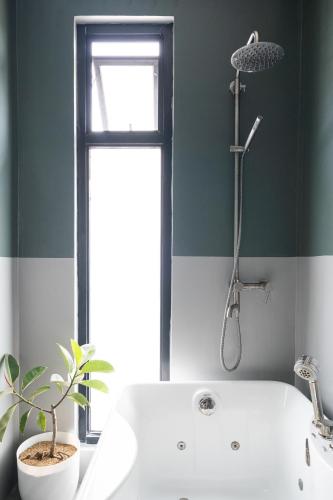 a bathroom with a white tub and a window at Modern 4 Bedroom House I Close to Malls I Swimming Pool I Maximum 12 Guests I by Bleuspace in Tagum