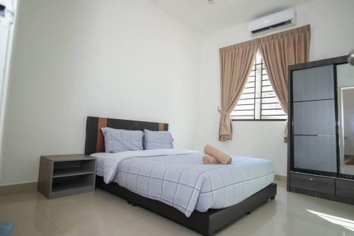 a bedroom with a large bed and a television at Rezeki Homestay@Harmonia2 Desaru in Bandar Penawar