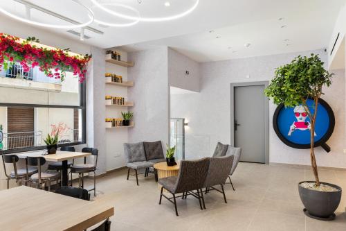 a room with tables and chairs and a plant at The Q Hotel in Athens